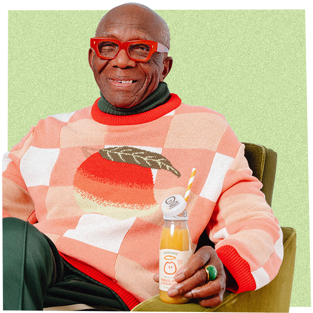 a man wearing big knitwear drinkng an innocent smoothie